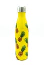 Still life of yellow thermos bottle with pineapples on it Royalty Free Stock Photo