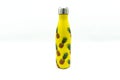 Still life of yellow thermos bottle with pineapples on it Royalty Free Stock Photo