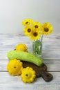 Still life of zucchini and flowers. Contrast of colors between yellow and green. Harvest healthy foods