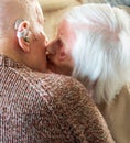 Elderly couple kissing and showing affection towards one another,living with alzheimer`s and dementia at their home in Hampshire,