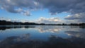 A still, reflective marsh pool mirroring a cloudy sky and emergent aquatic vegetation in late afternoon. Royalty Free Stock Photo
