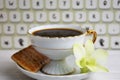 Stilllife of coffee cup with espresso, croissant or biscuit, flower and imitation of keyboard on a wooden background