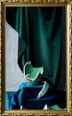 Stilllife with remnants of broken teal colored vase, emerald green and dark blue velvet, and picture frame