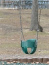 An Empty Green Kiddie Swing in a Park or Playground