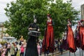 Stilt Dancers and a Drummer Performing at a Street Carnival.