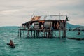 Stilt houses in a bajau sea gypsy village next to a small island rock outcrop