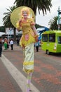 A female stilt walker dressed in yellow