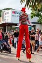 Male stilt walker in clown costume on street