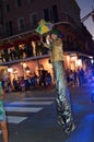 A stilted costumed man welcomes New Orleans revelers to a party boat