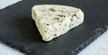 Stilton blue mold cheese wedge close up on black slate cheese bo Royalty Free Stock Photo