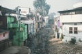 A stinking sewage flow in the slums. Poor area of Haridwar, India. House poor people on the hillside in front of a dirty river.