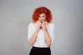 Stinky. Closeup portrait young red head business woman pinches her nose with fingers looks with disgust something stinks bad smell Royalty Free Stock Photo