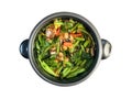 STIR FRIED CHINESE KALE WITH CANNED FISH taste spicy with chili cooking in the black pot isolated in white background.