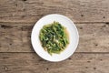 Stir Fried Morning Glory in plate on wood background, Phad Puk Boong, Thai Food, Flat lay composition, Top view