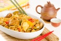 Stir-fried noodles with chicken and vegetables served in a bowl, over bamboo mat with tea Royalty Free Stock Photo