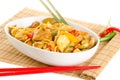 Stir-fried noodles with chicken and vegetables served in a bowl, over bamboo mat with chopsticks and chili pepper Royalty Free Stock Photo
