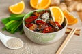 Stir-fried orange ginger tofu with sesame onion and chili spices in a bowl with chopsticks on a table Royalty Free Stock Photo