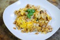 Stir fried pickle turnip with egg in white plate on wooden table