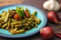 Stir fried pork belly and red curry paste with sting bean served in a blue plate on a wooden table Royalty Free Stock Photo