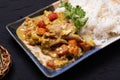 Stir fried pork curry powder with steamed rice in a plate on a black background Royalty Free Stock Photo