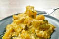 Stir fried pumpkin mixed with egg stabbing in silver fork on plate