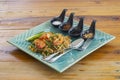 Stir Fried Rice Noodle Thai style with Prawns, side dishes and condiments or Thai people call Pad thai in plate on wooden table. Royalty Free Stock Photo