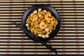 Stir fried rice noodles Pad Thai with prawns and tofu in plate on bamboo mat. Top view. Thai food Royalty Free Stock Photo