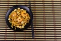 Stir fried rice noodles Pad Thai with prawns and tofu in plate on bamboo mat. Top view. Thai food Royalty Free Stock Photo