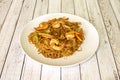 Stir-fried rice noodles with peeled shrimp and vegetables in a wok with recipe Royalty Free Stock Photo