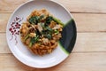 Stir-fried rice noodles, soy sauce with pork and kale in the dish, Thai delicious food isolated on wooden background closeup. Royalty Free Stock Photo