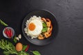 Stir-fried shrimp with basil Thai street food arranged on a black plate with a fried egg Thai spicy food Placed on a dark black