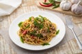 Stir fried Spaghetti with Canned tuna fish and crispy basil leaves in white plate,Spicy pasta Pad Kra Pao