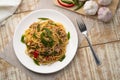Stir fried Spaghetti with Canned tuna fish and crispy basil leaves in white plate,Spicy pasta Pad Kra Pao.Thai fusion food
