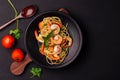 Stir-fried spaghetti or stir-fried noodles Tomato sauce and prawns on a black plate On a wooden table background. Top view Royalty Free Stock Photo