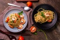 Stir-fried spaghetti or stir-fried noodles Tomato sauce and prawns on a plate and tomato basil on wooden table background, top Royalty Free Stock Photo