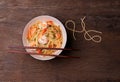 Stir-fried spaghetti or stir-fried noodles Tomato sauce and prawns on a plate and tomato basil on wooden table background, top Royalty Free Stock Photo