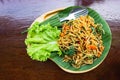 Stir Fried Spaghetti with vegetables and pork in wooden tray bowl put on dark brown wood table. Top view Royalty Free Stock Photo