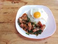 Stir fried spicy crispy pork with thai basil and fried egg.