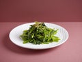 Stir-Fried Spinach with Garlic with chopsticks served in a dish isolated on mat side view on grey background Royalty Free Stock Photo