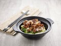 Stir-fried Tender Pork Collar with Supreme Soya Sauce with chopsticks served in a pot isolated on mat side view on grey background Royalty Free Stock Photo