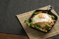 Stir-fried Thai basil with minced pork meat, carrots, and baby corns, with fried egg and fresh Thai basils sort in a black small Royalty Free Stock Photo