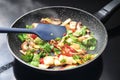Stir-fried vegetables steaming in a frying pan, healthy vegetarian cooking with ingredients like bell pepper, mushroom, onions and