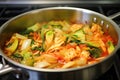 stir fry kimchi being cooked in a hot pan