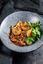 Stir fry Rice noodles with shrimps and vegetables. Asia wok. Black background. Top view