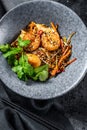 Stir fry Rice noodles with shrimps and vegetables. Asia wok. Black background. Top view