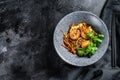 Stir fry Rice noodles with shrimps and vegetables. Asia wok. Black background. Top view. Copy space