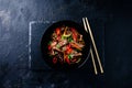 Stir fry soba noodles with beef and vegetables in wok on dark background, Asian noodles with beef WOK in black bowl Royalty Free Stock Photo