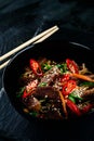 Stir fry soba noodles with beef and vegetables in wok on dark background, Asian noodles with beef WOK in black bowl Royalty Free Stock Photo