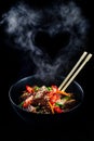 Stir fry soba noodles with beef and vegetables in wok on dark background, Asian noodles with beef WOK in black bowl Royalty Free Stock Photo