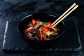 Stir fry soba noodles with beef and vegetables in wok on dark background, Asian noodles with beef WOK in black bowl Royalty Free Stock Photo